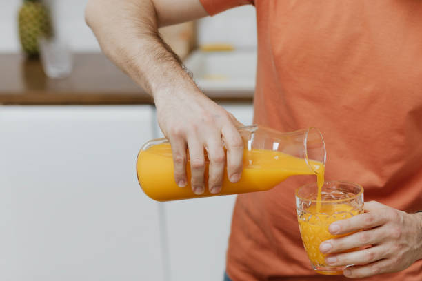 Man pouring orange juice into a glass