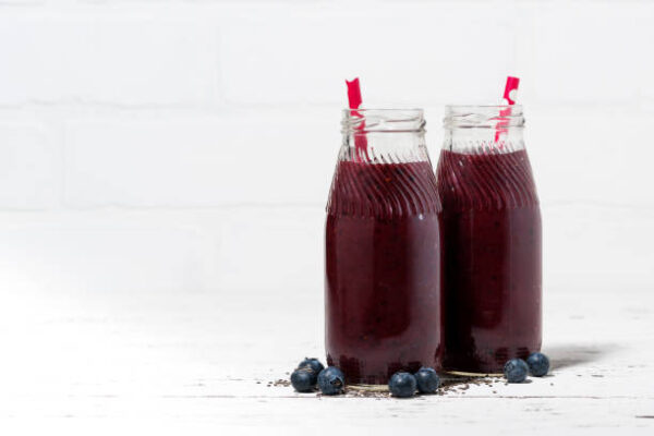 Healthy berry smoothie in jars on white background, horizontal