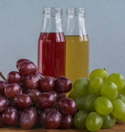 Various freshly squeezed fruits juices on wooden background