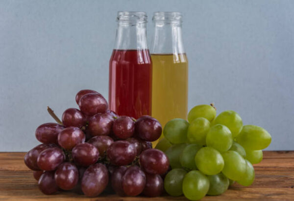 Various freshly squeezed fruits juices on wooden background